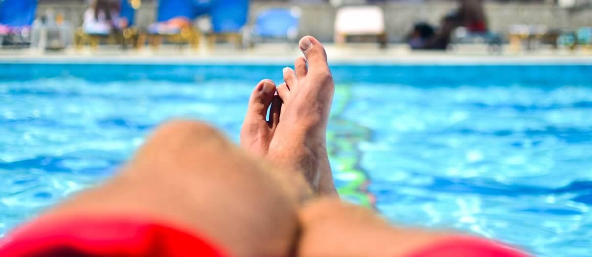 Mans feet and swimming pool